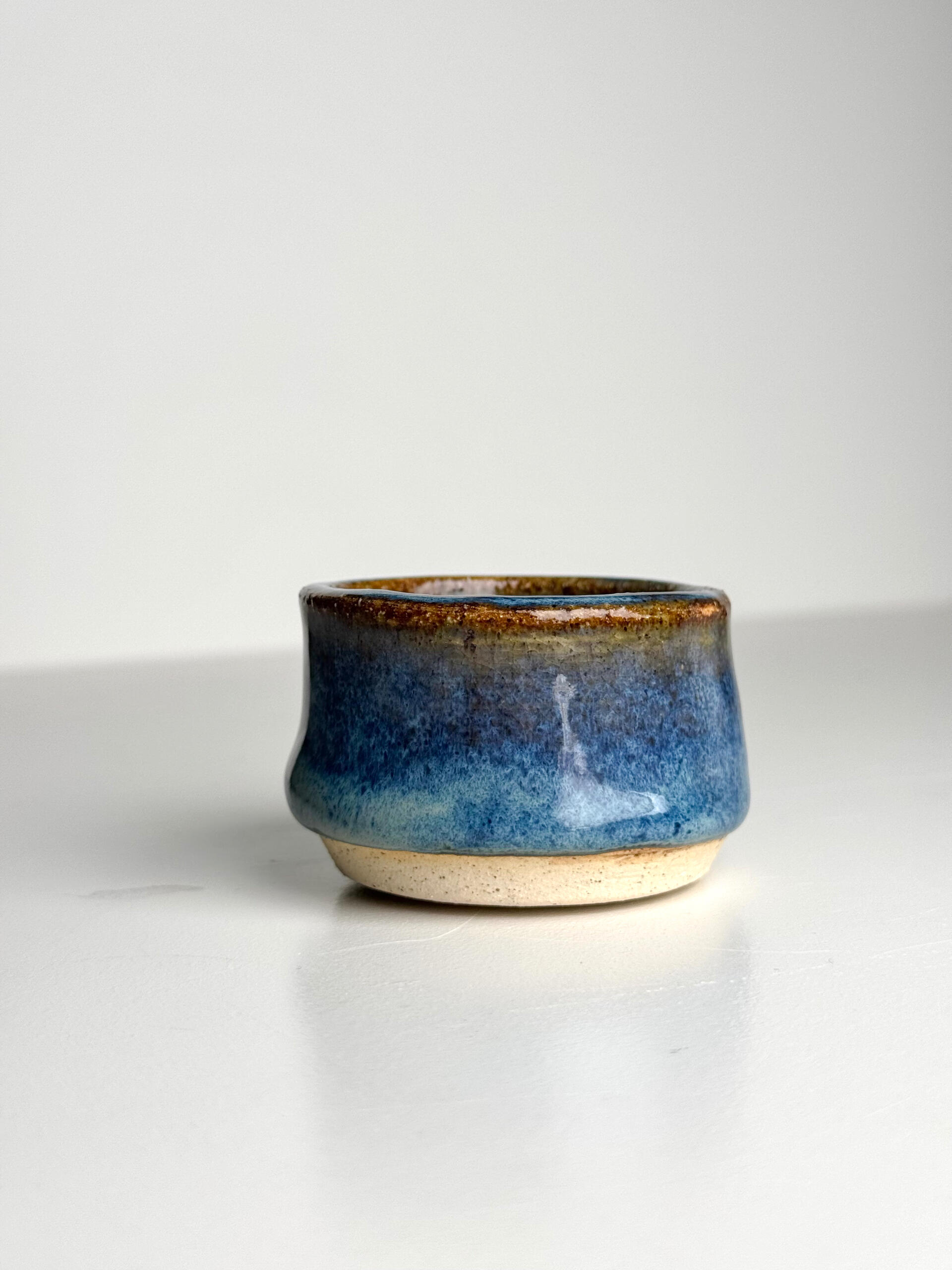Blue Gradient Yunomi Cup Small handmade ceramic cup with flowing blue glaze over natural clay base, sitting on a white surface